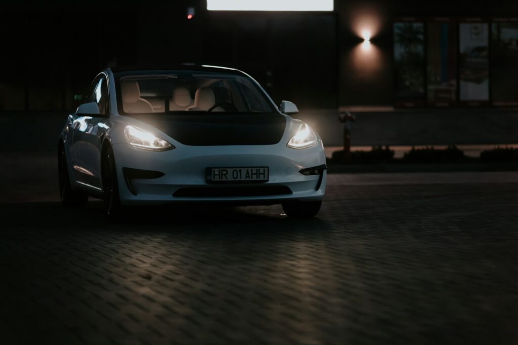 a white car parked in front of a building at night