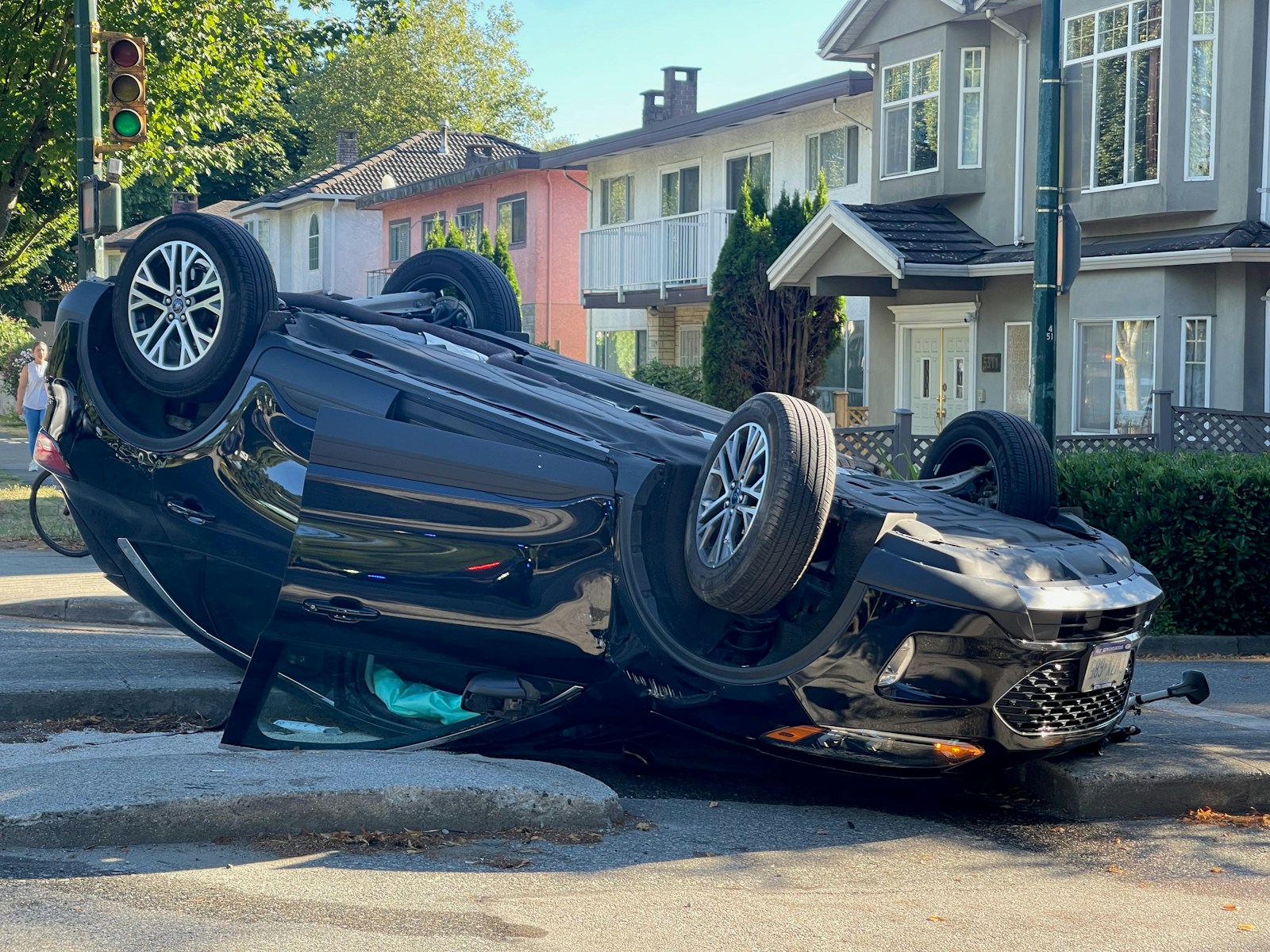 A car overturned on its side on a street.
