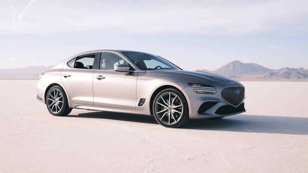 a silver car is parked in the middle of the desert