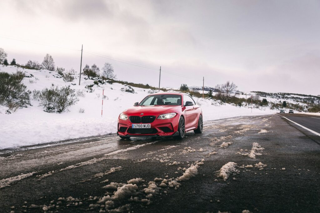 Red car driving on a snowy road
