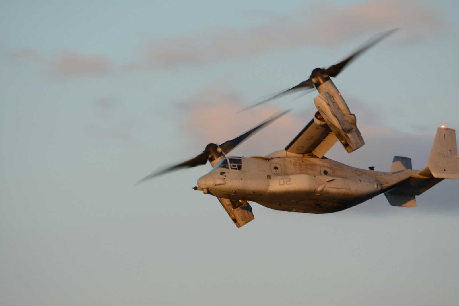 A tiltrotor aircraft flying in the sky.