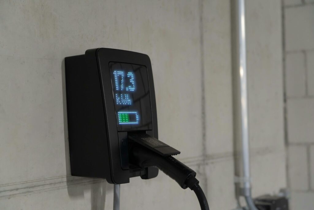 Electric car charger mounted on wall with display.