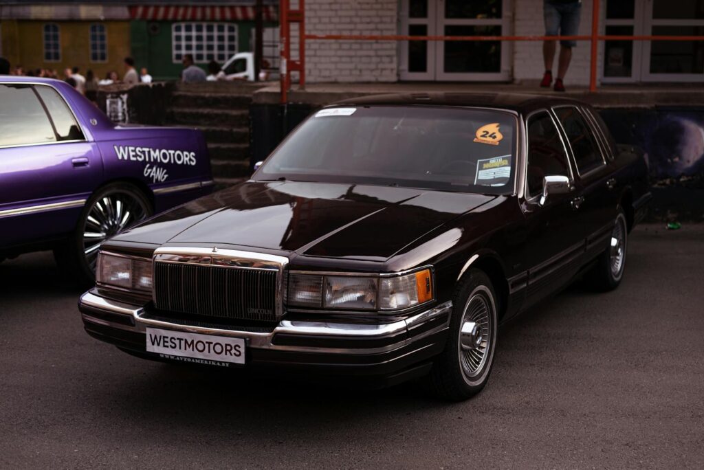 Shiny black sedan at an outdoor car exhibition in Minsk, Belarus.