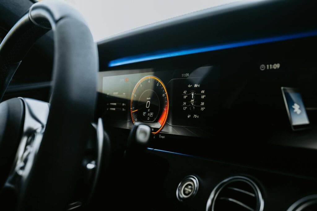 Close-up view of a sleek car dashboard featuring an illuminated digital display and steering wheel.