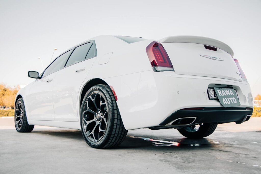 A rear view of a sleek white Chrysler 300 parked in sunny Erbil, Iraq.