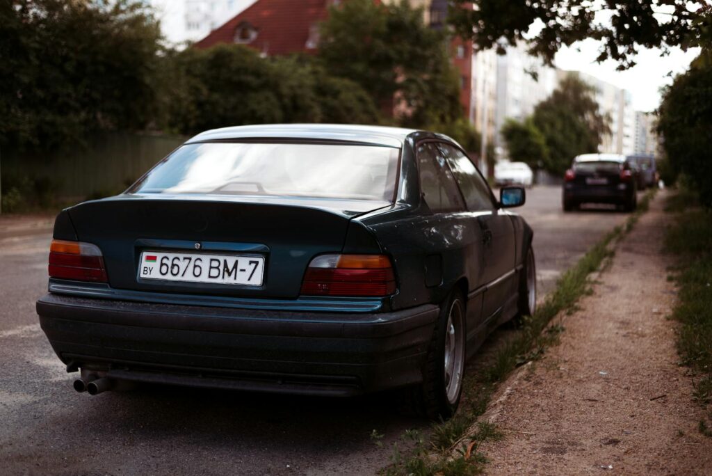 Rear view of a classic car parked on a city street during the day.