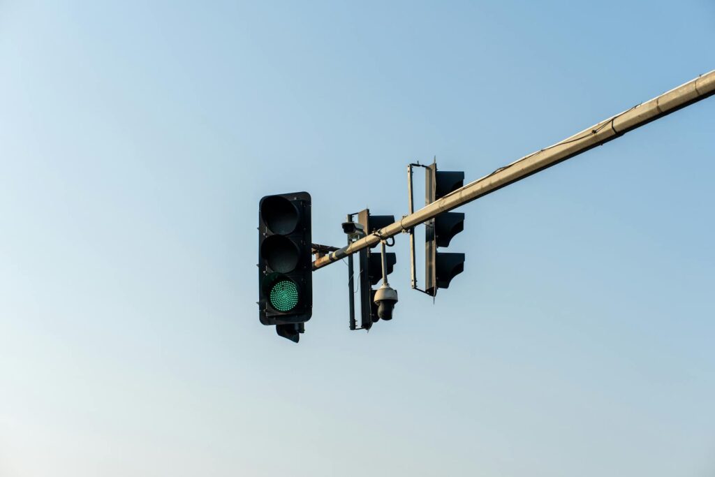 A green traffic light captures the start of a journey under a clear blue sky.