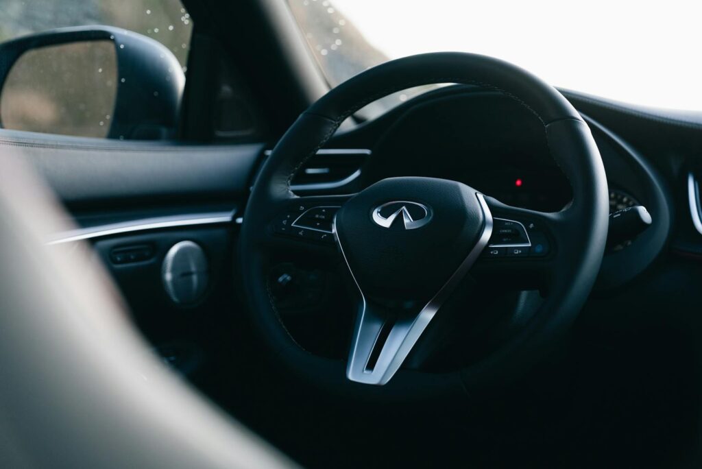 Close-up shot of a luxury car steering wheel showcasing sleek design and elegance.