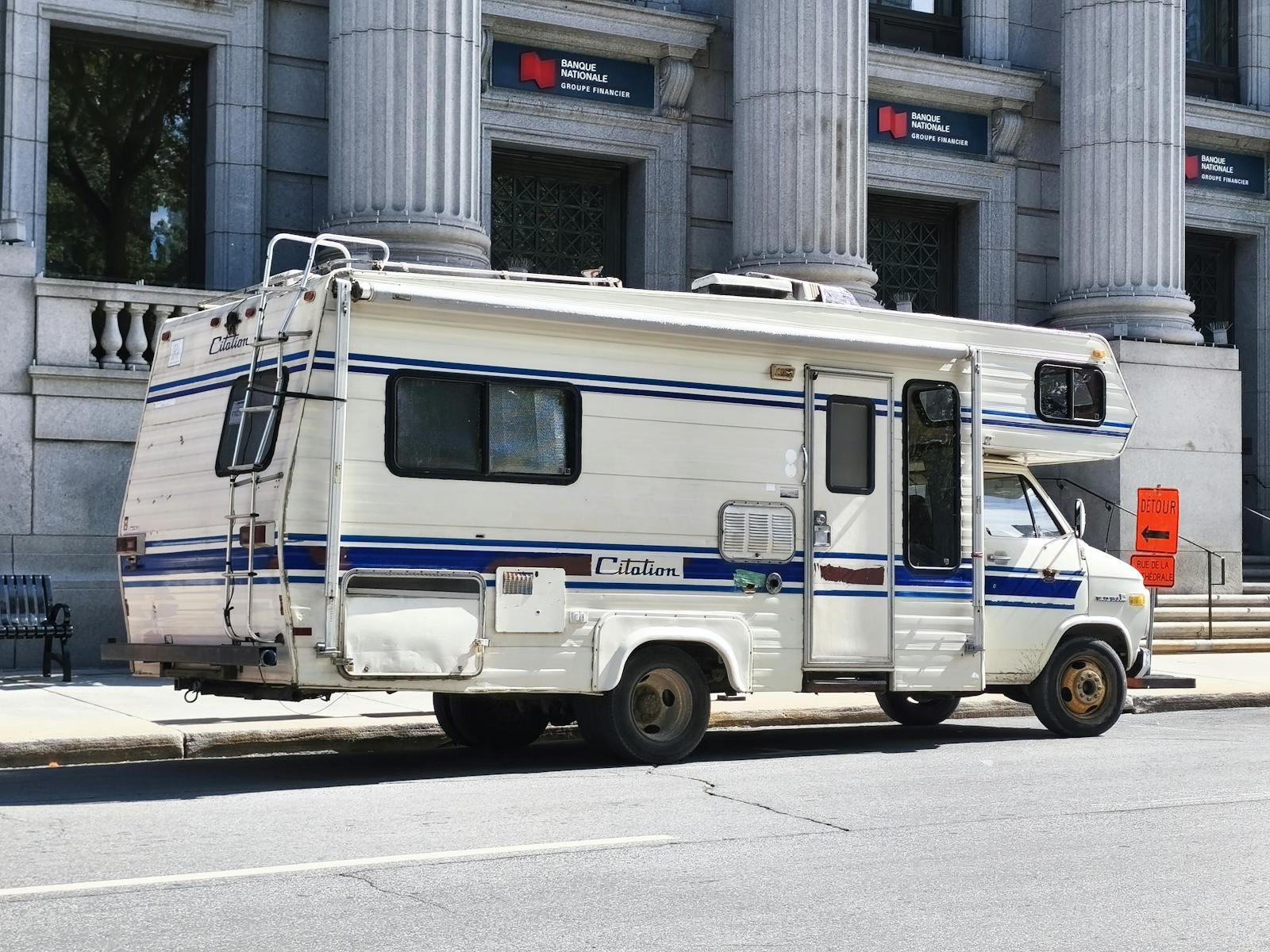 A classic Citation camper van parked in the city near a historic building.