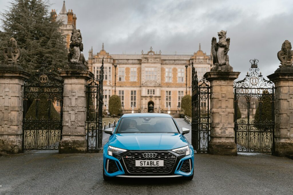 a blue car parked in front of a gated building