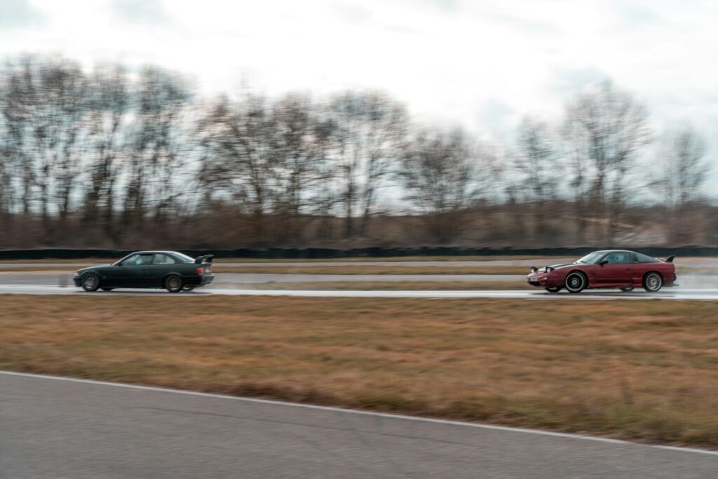 a couple of cars driving down a wet road