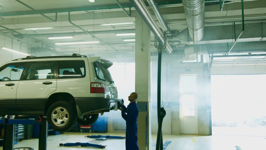 Mechanic conducts vehicle inspection in an automotive garage setting.