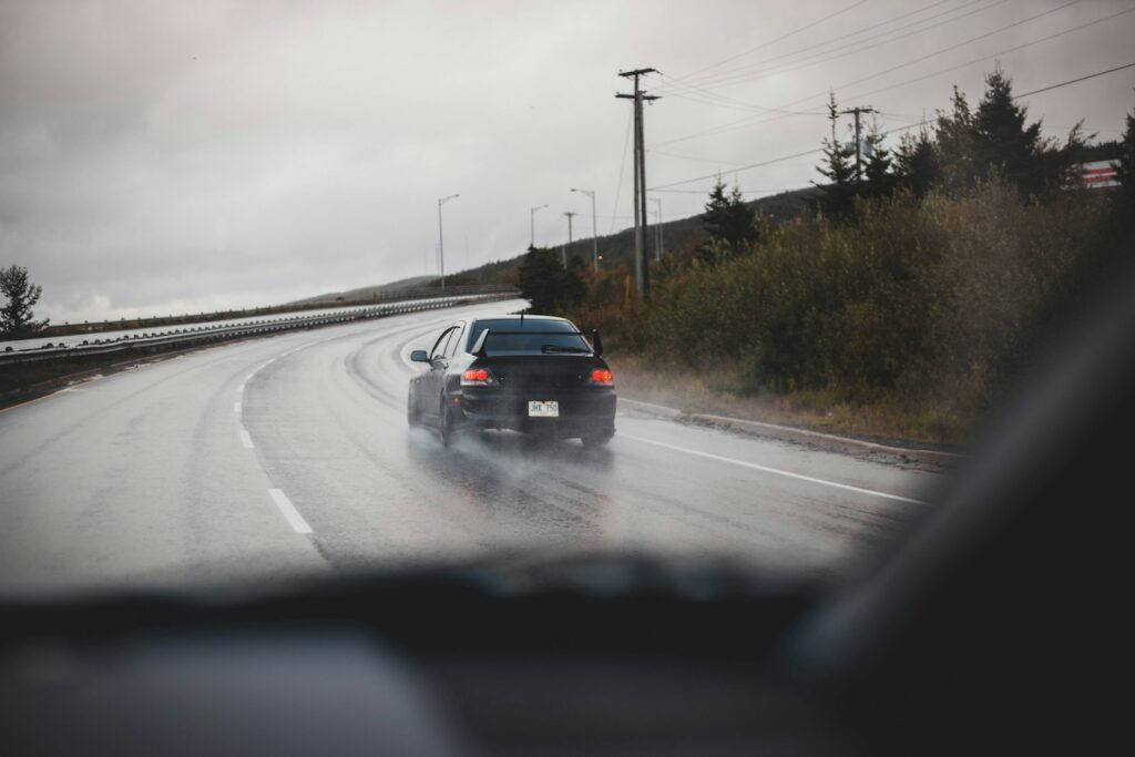 a car driving down the road in the rain