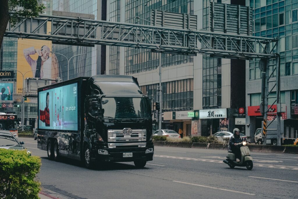 Black truck with digital billboard drives on city street