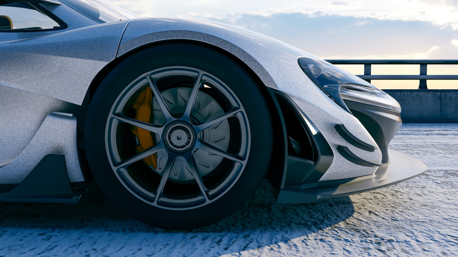 Sleek, silver sports car shows off its wheel.
