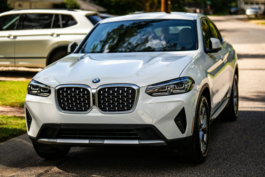 A white BMW suv parked on the side of the road