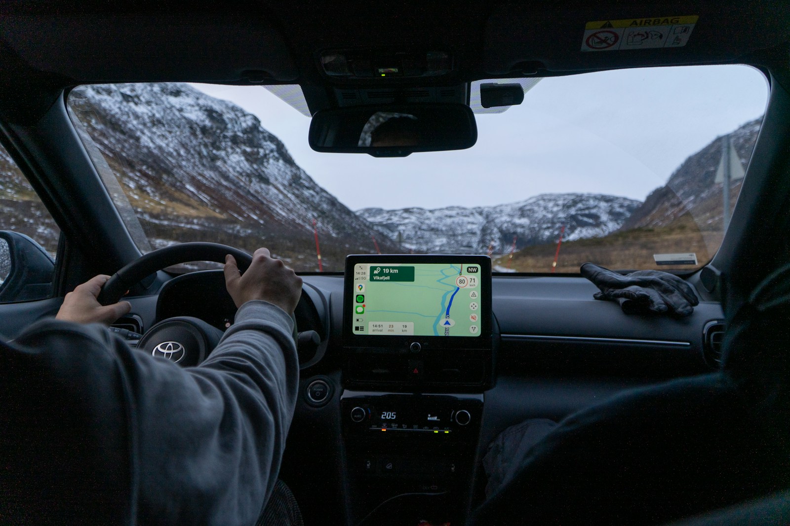 A man driving a car with a gps device in his hand