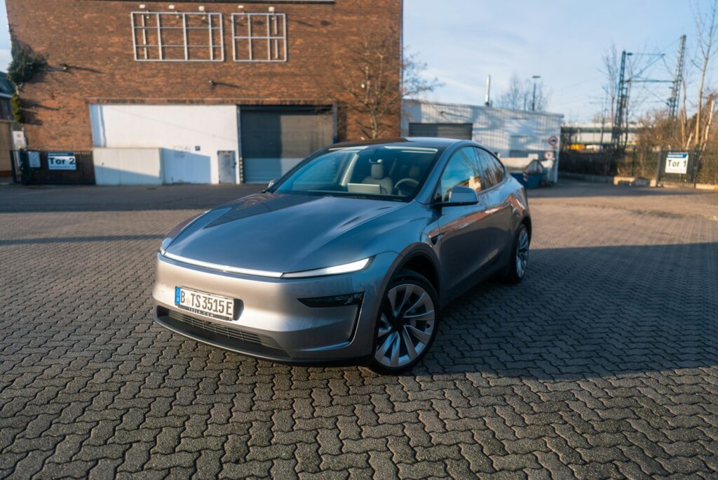 A silver car parked in front of a brick building