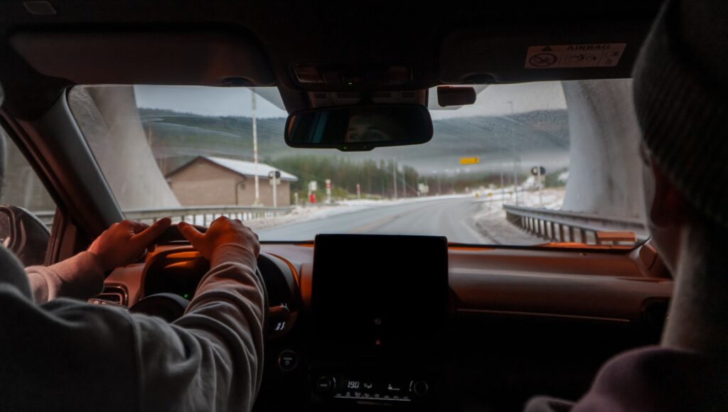 A man driving a car down a road