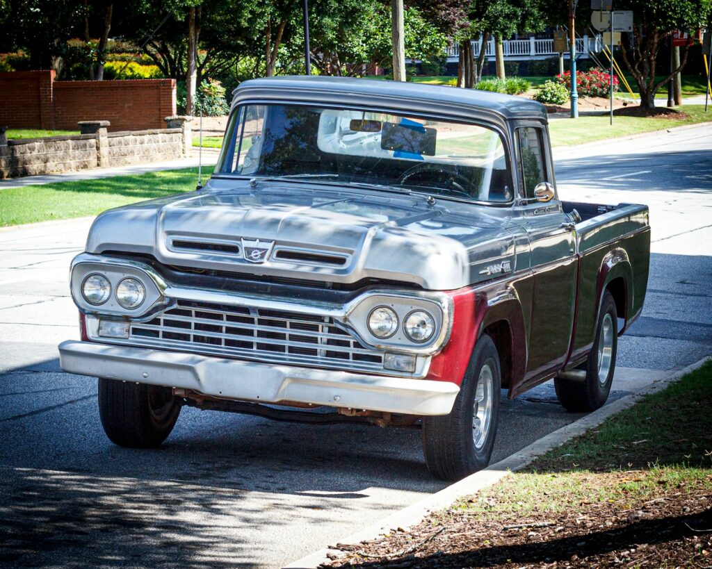 Here is a possible caption: a classic ford pickup truck is parked on the street.