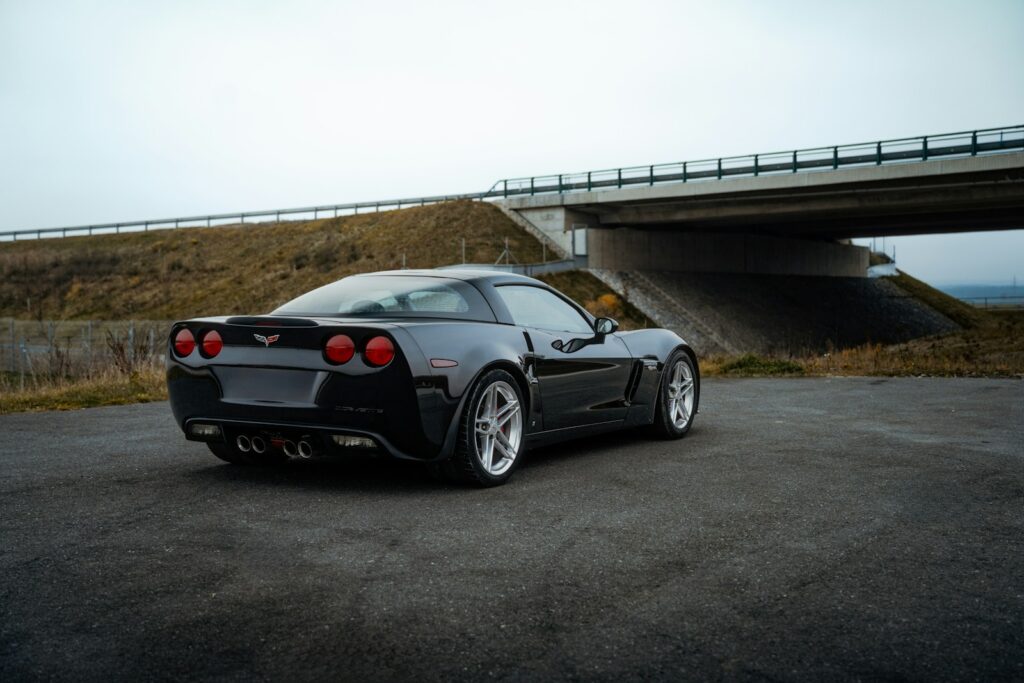 A black sports car parked in front of a bridge