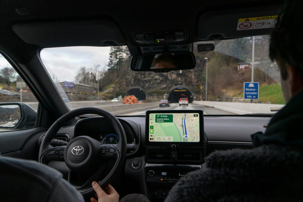A man driving a car with a gps device in his hand