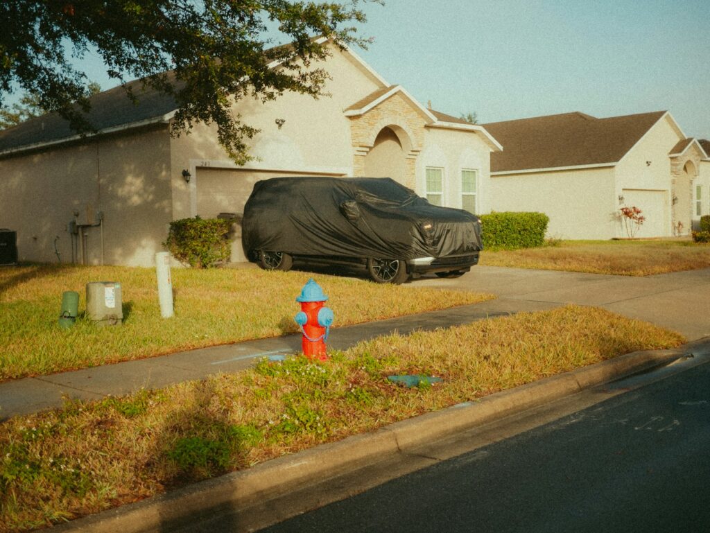 A car parked on the side of a road in front of a house