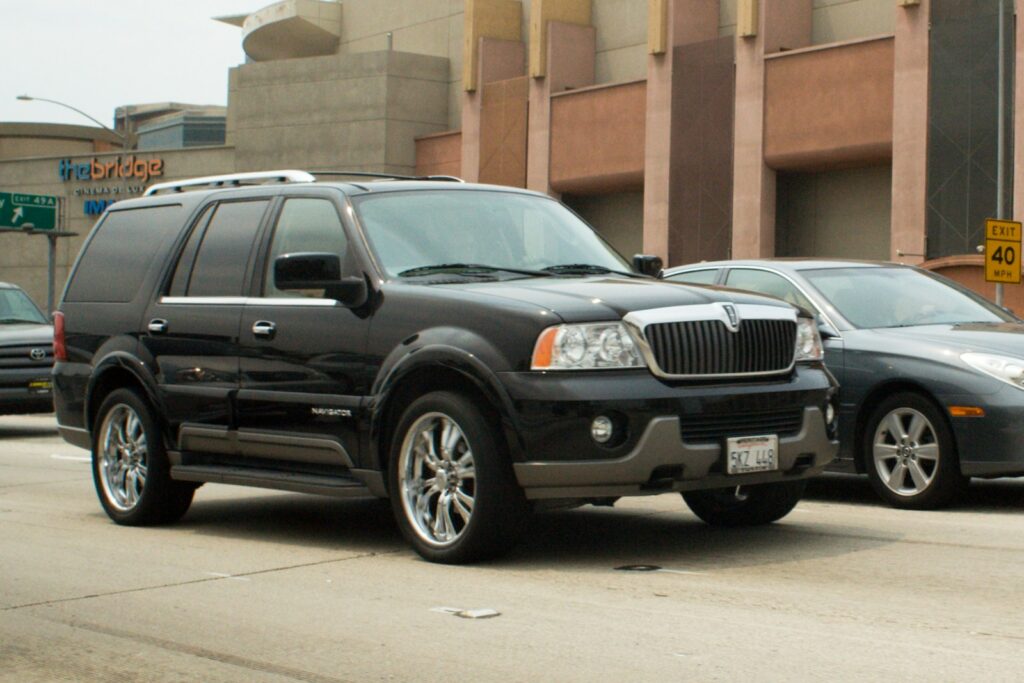 Black lincoln navigator driving on a city street.