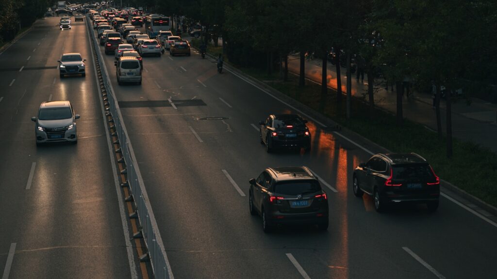 A highway filled with lots of traffic next to trees