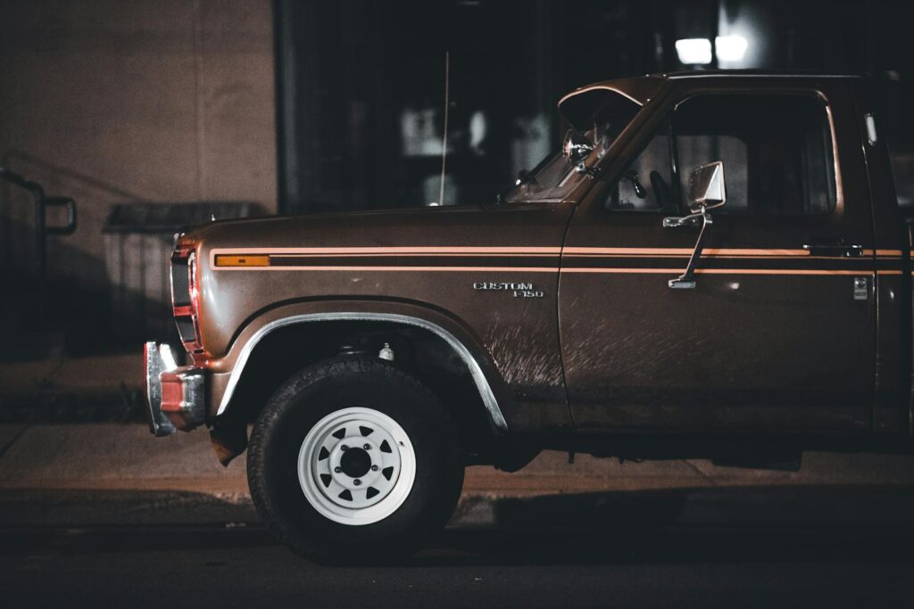 Classic Ford pickup truck parked on a city street at night, showcasing vintage style and nostalgia.