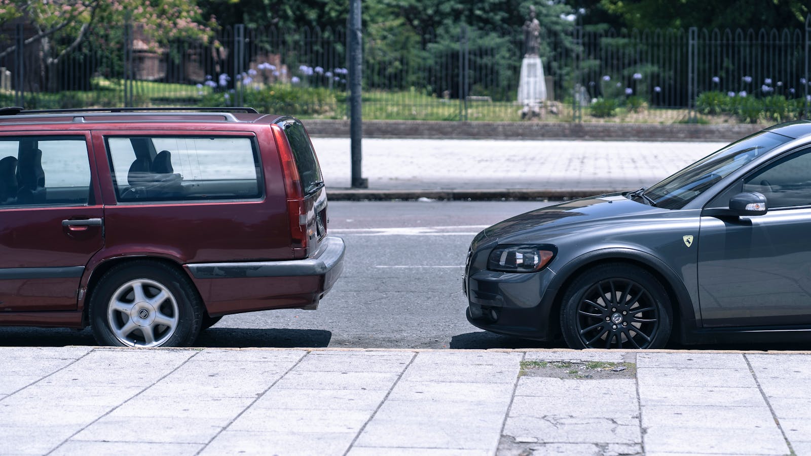 Two parked cars on a sunny street in La Plata, Argentina, showcasing a classic urban cityscape view.