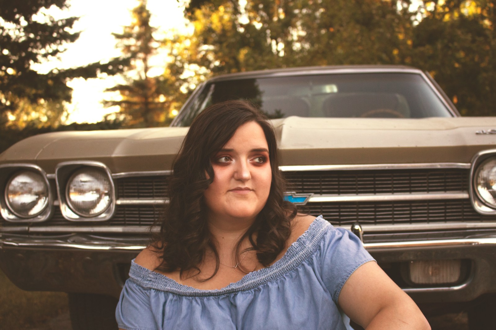 woman sitting near brown classic car