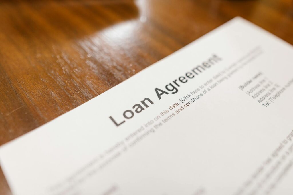 Detailed loan agreement document close-up on a wooden table representing legal and financial concepts.