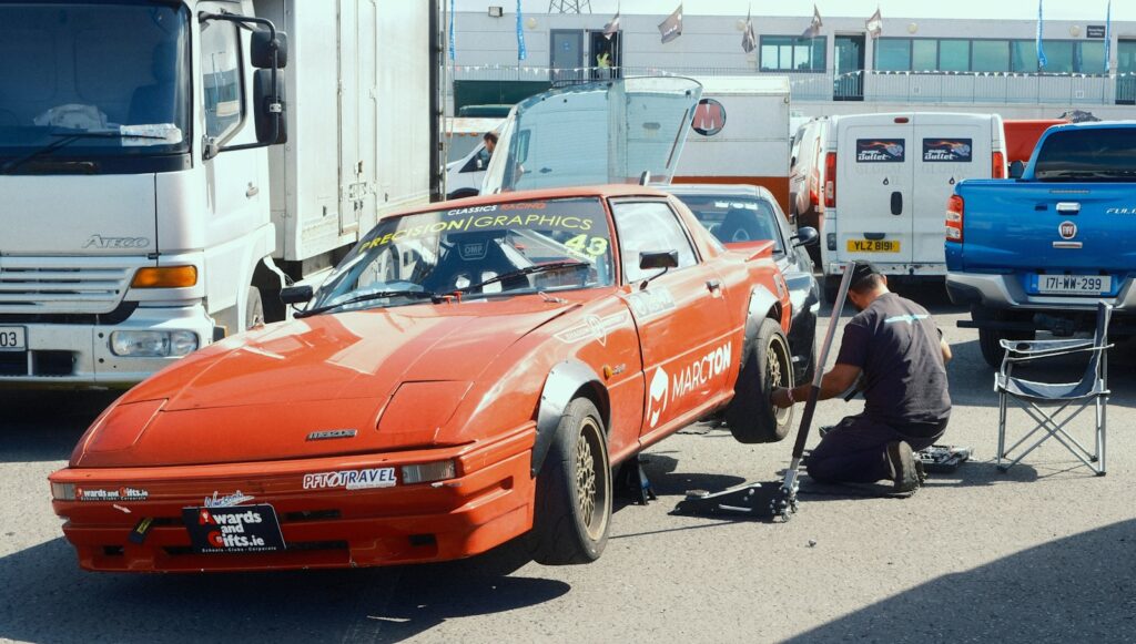 A man working on a car in a parking lot