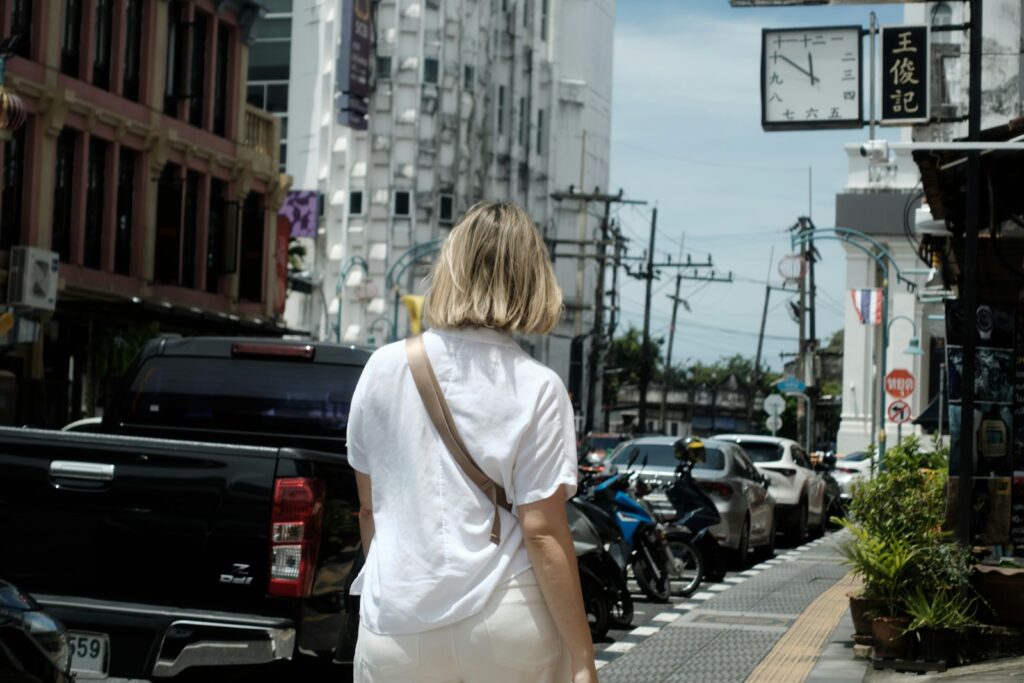 Woman walks down a busy city street.