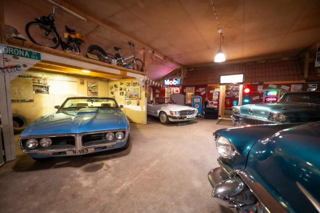 Classic cars are displayed inside a garage.