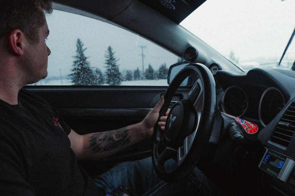 person in blue denim jeans driving car