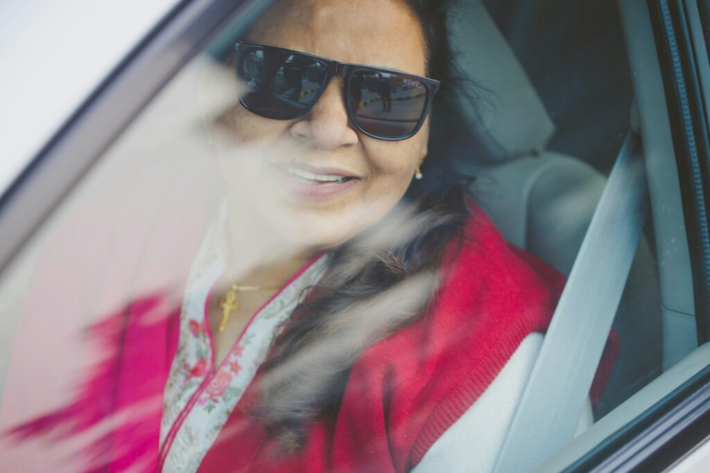 a woman wearing sunglasses sitting in a car