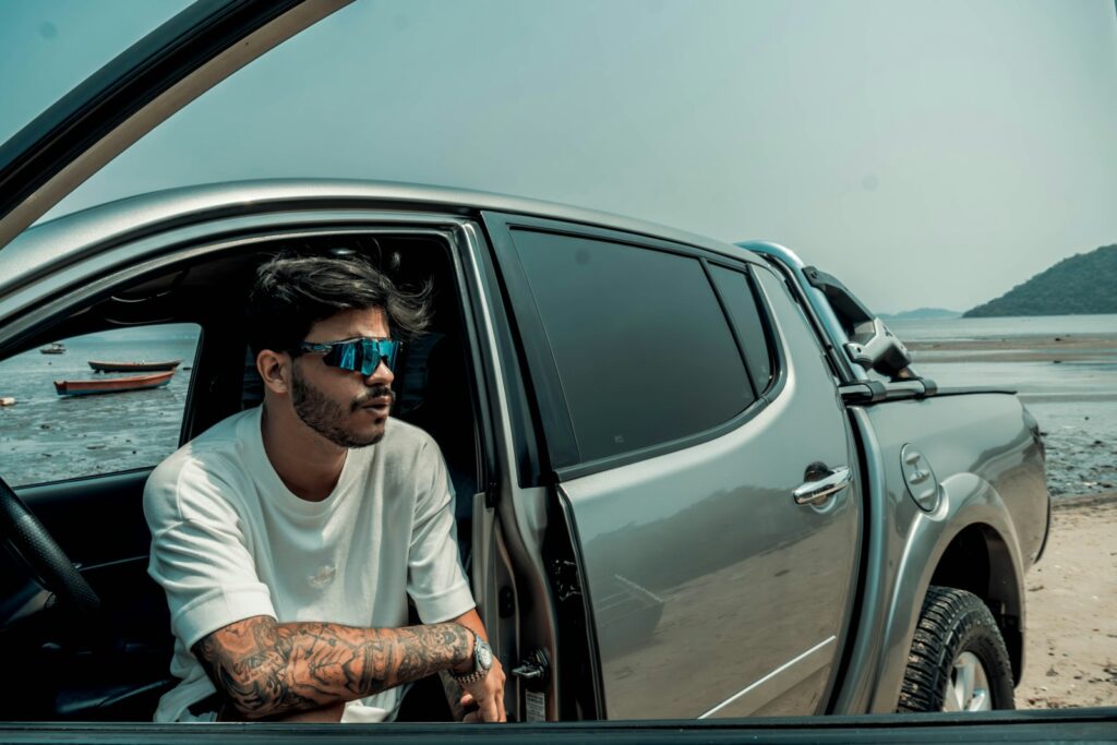 A man sitting in the driver's seat of a silver truck