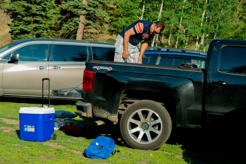 A man standing on the back of a black truck