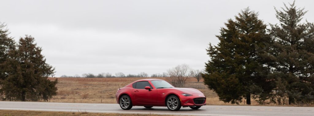 a red sports car driving down the road