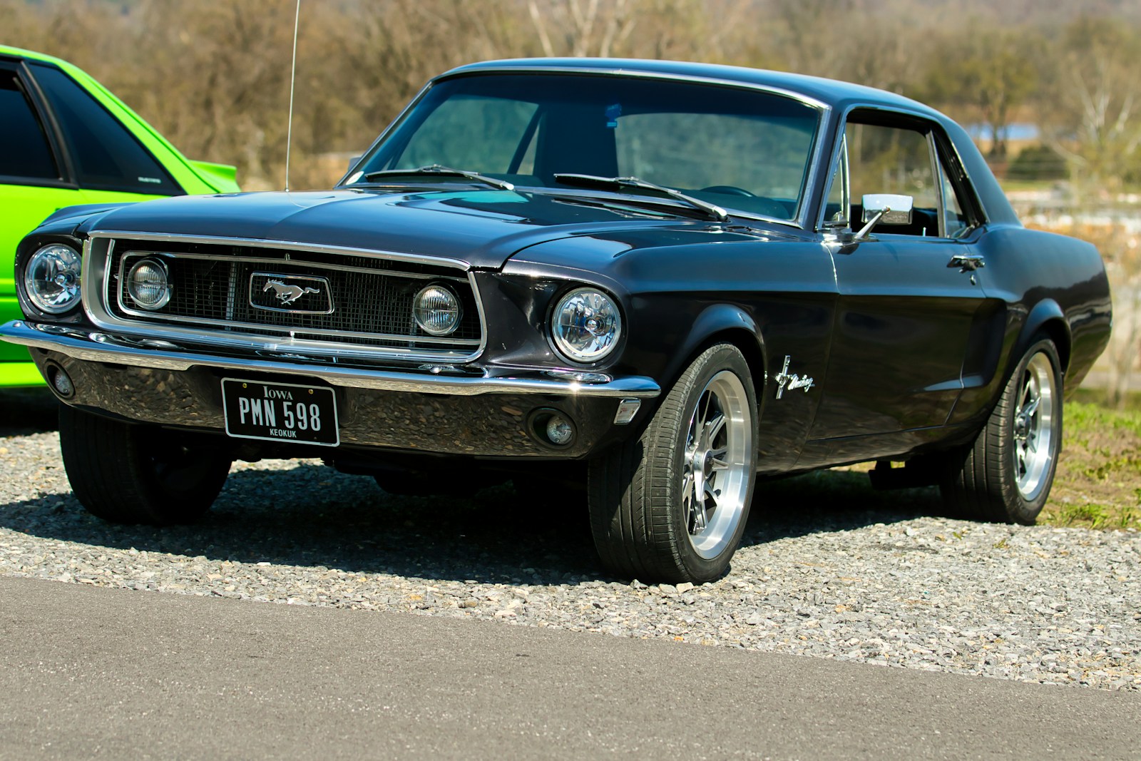 A classic black ford mustang parked outdoors.