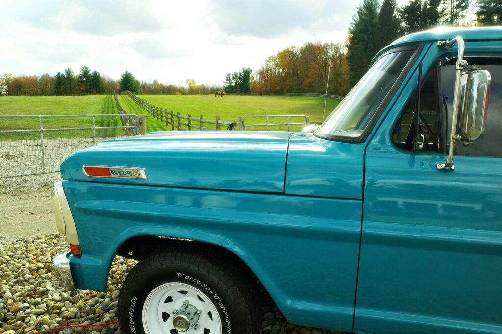 Turquoise vintage truck in a rural landscape.