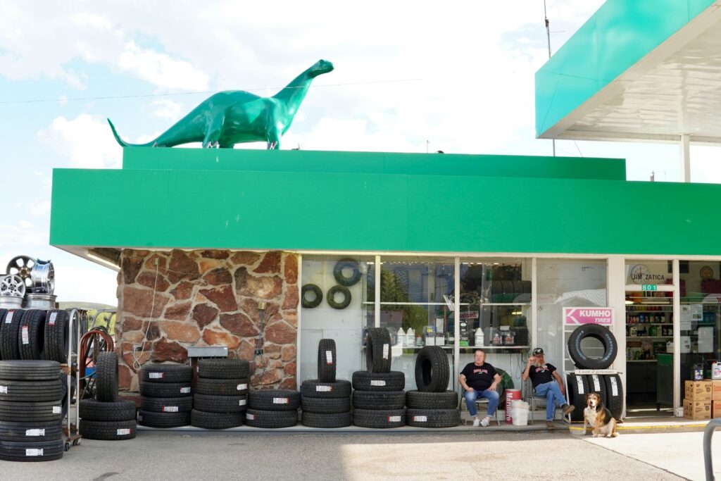 two men sit in front of a tire shop