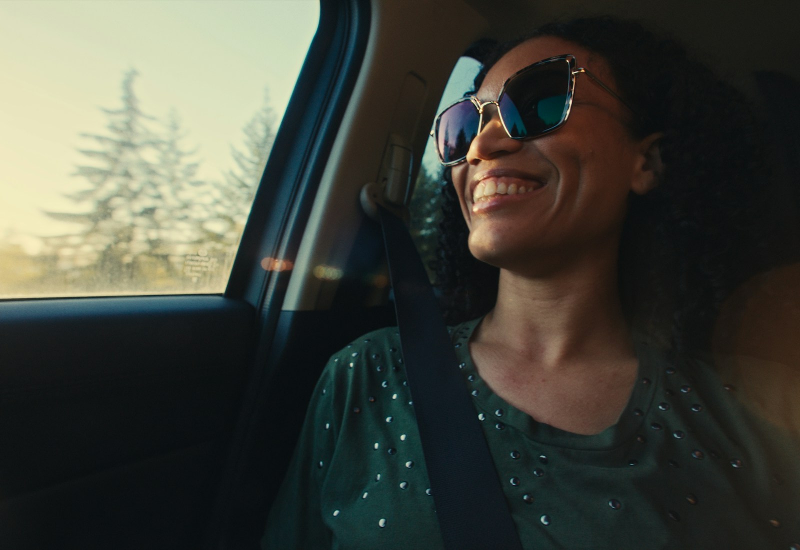 Happy woman smiling and enjoying a car ride.