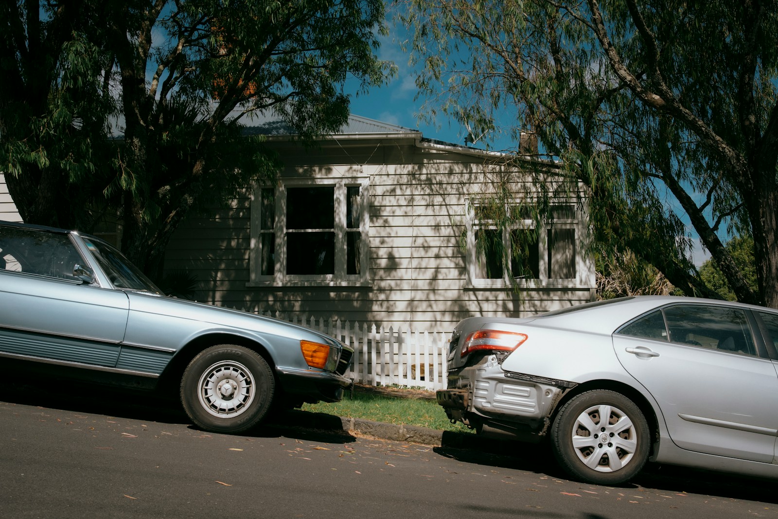 Cars are parked in front of a house.