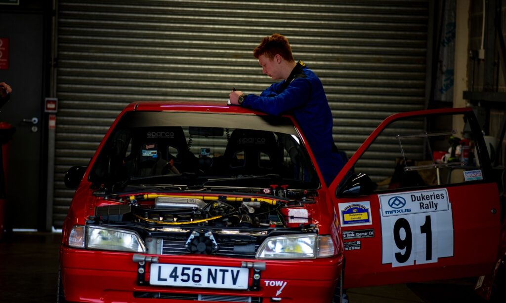 a woman working on a car in a garage