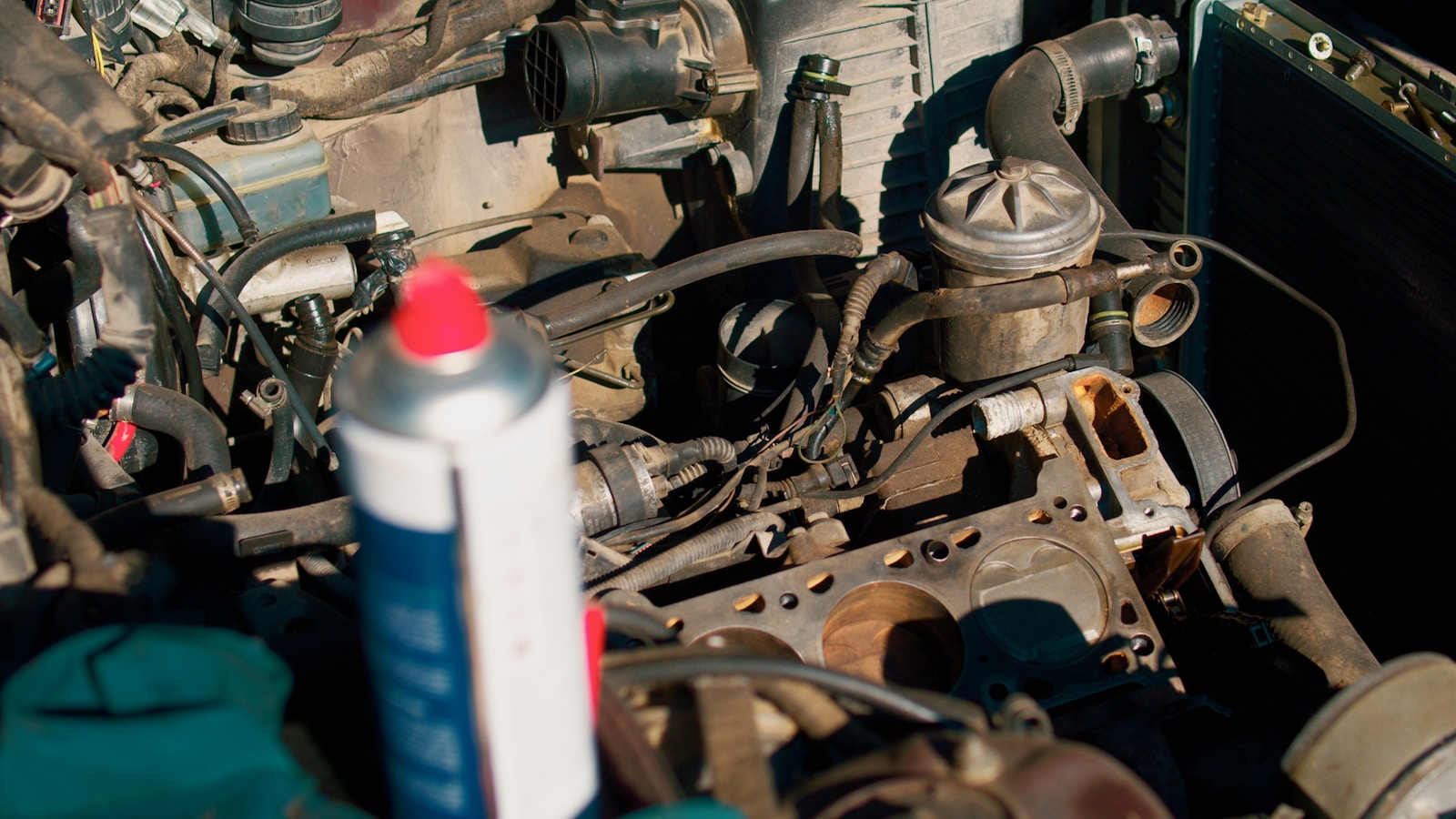 A close up of a car engine with a tube of glue