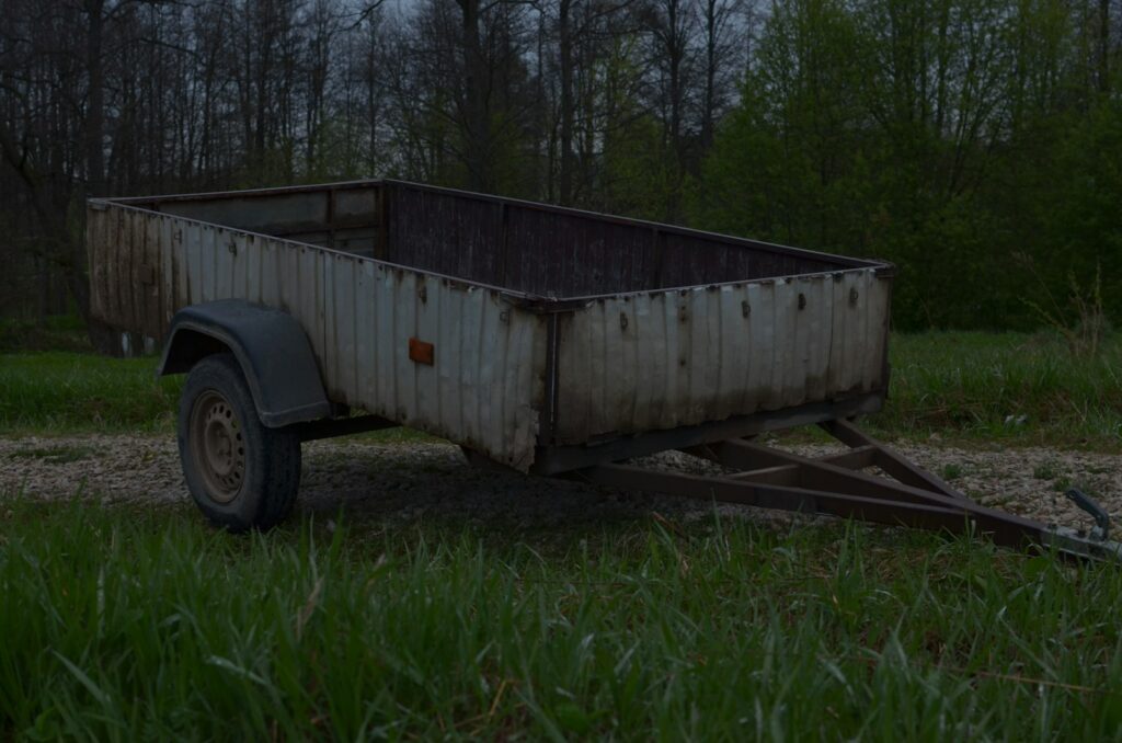 a rusty trailer in a field