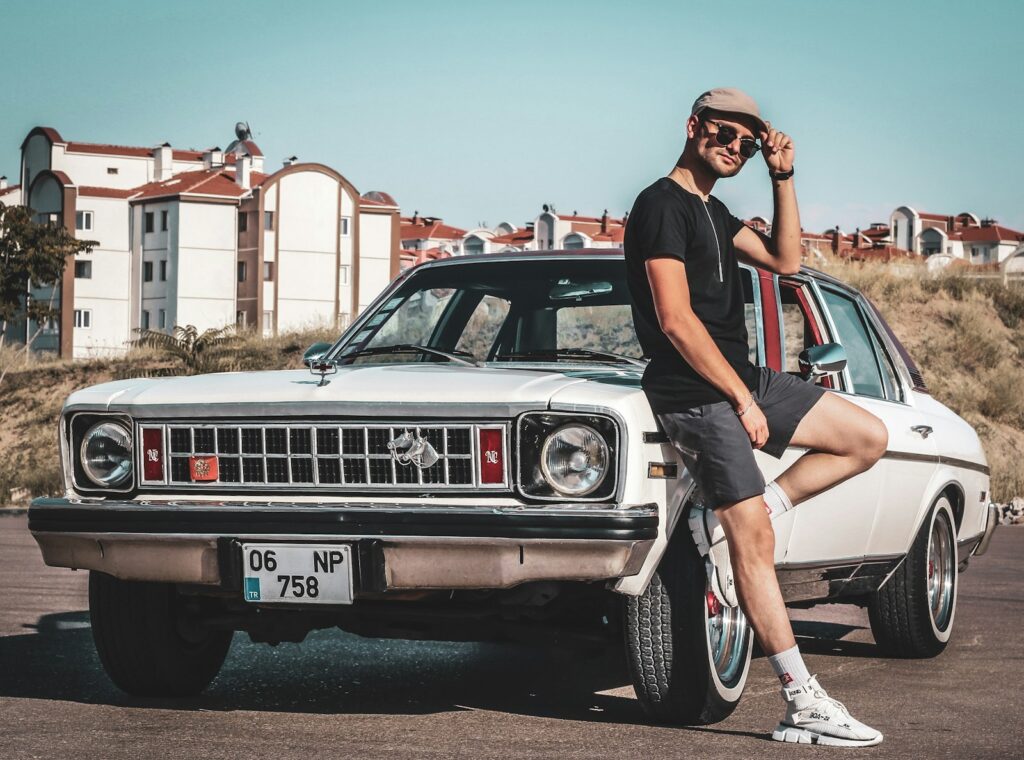 a person posing next to a car